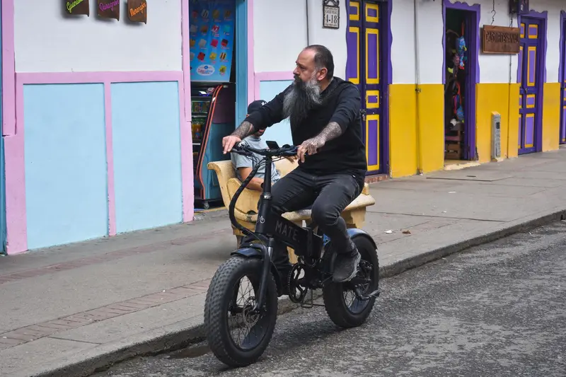 Rider pausing on an electric bike on a city street, checking a phone