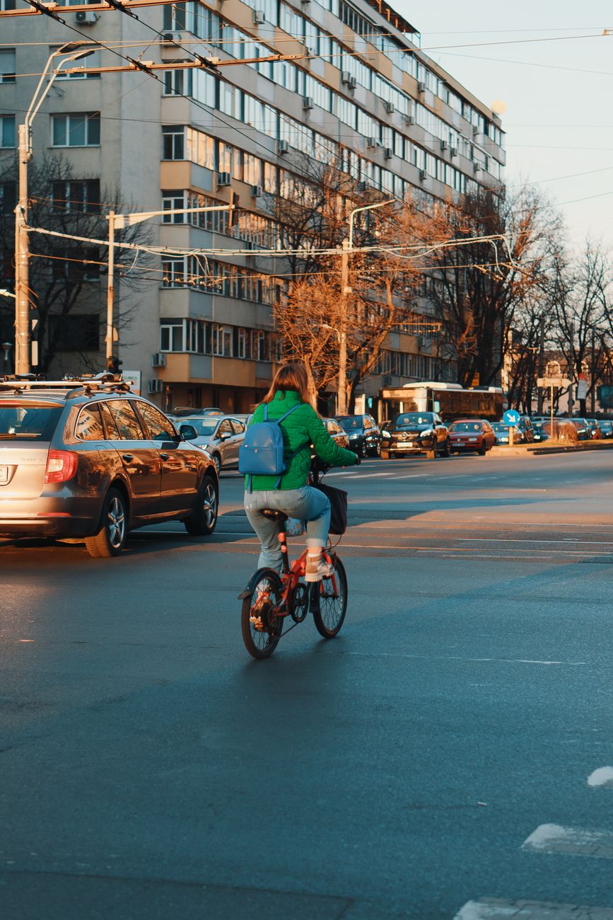 Rider on an electric commuter bike stopped at a city crossing, panniers loaded