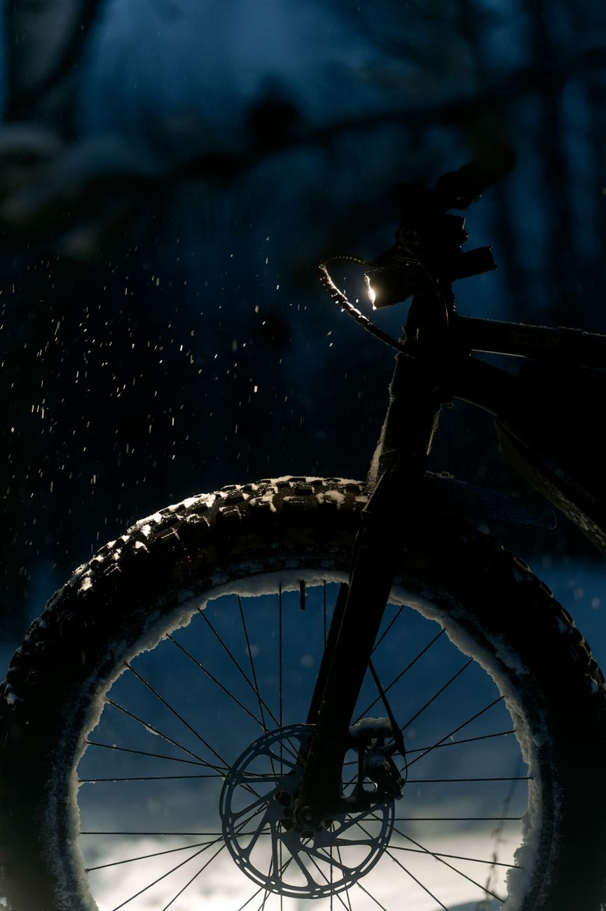 Fat tyre e-bike wheel cutting through fresh snow at dusk