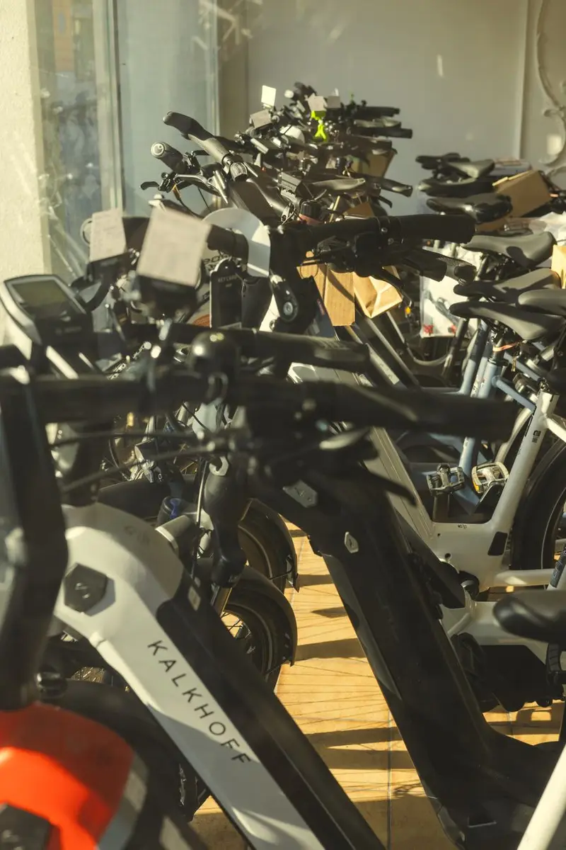 Rows of electric bikes lined up in a bright showroom for a buyer to compare