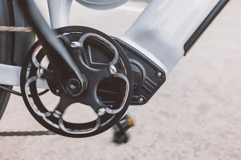 Close-up of an e-bike's mid-drive motor unit and crank mounted at the bottom bracket