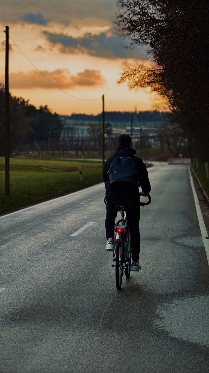 Cyclist riding a countryside road at sunset
